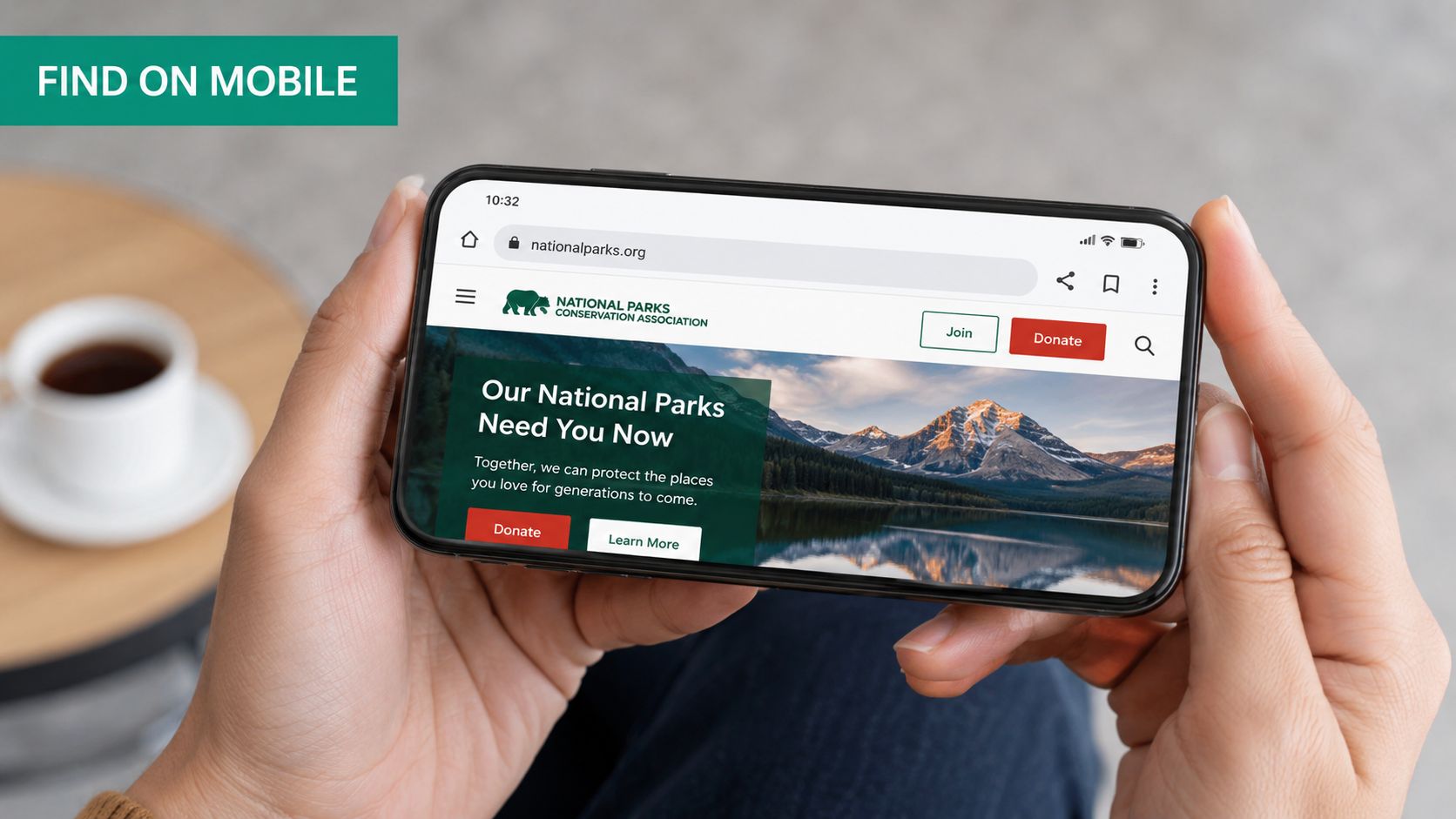 A close-up of a person holding a smartphone showing the national parks conservation association website.