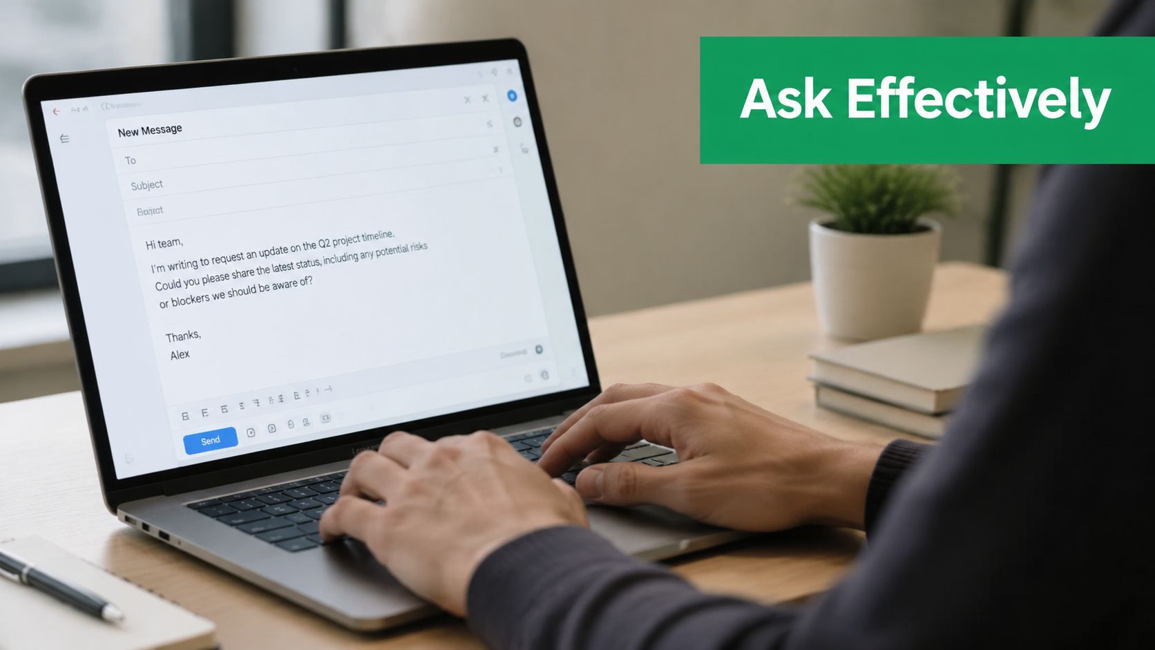 A person writing an email on a laptop computer about a project update in a professional office setting.